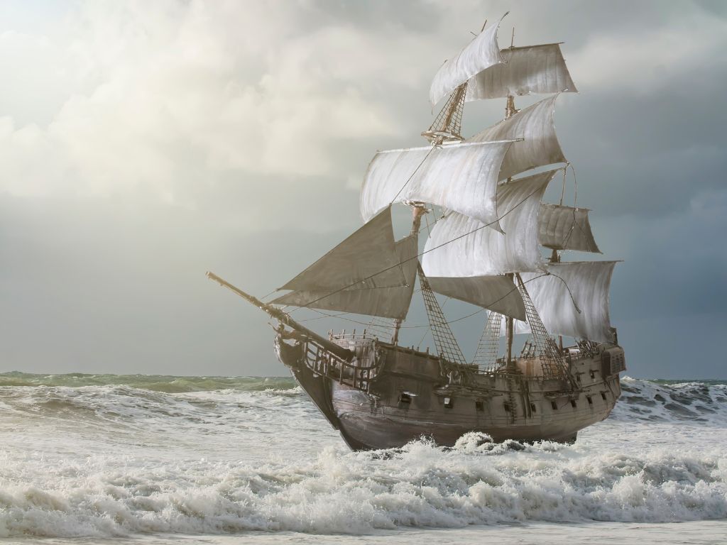 A large wooden sailing ship with several masts and white sails moves through choppy ocean waves under a cloudy sky.