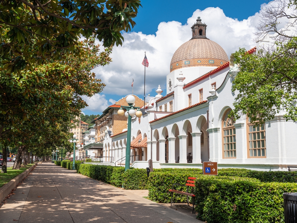 Historic Bathhouse Row in Hot Springs, Arkansas, with a domed spa building and tree-lined walkway in a cozy inland winter boating destination.