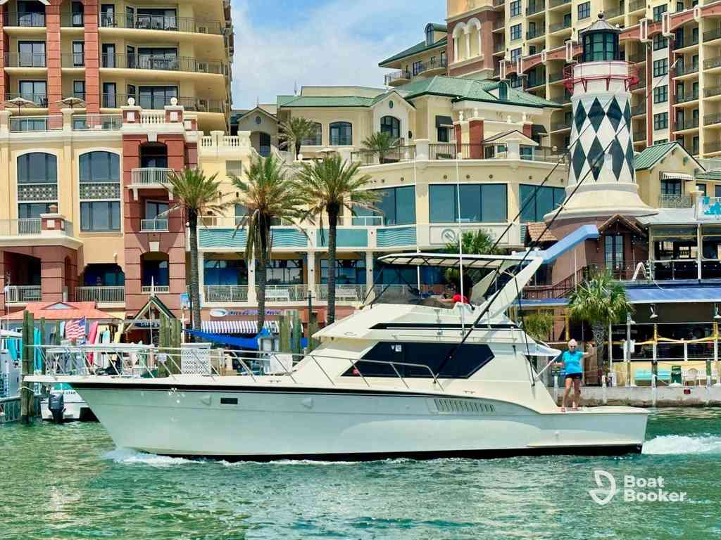 A white motor yacht's cruising near a dock by colorful waterfront buildings and palm trees—a classic scene for anyone with a Florida boating license.