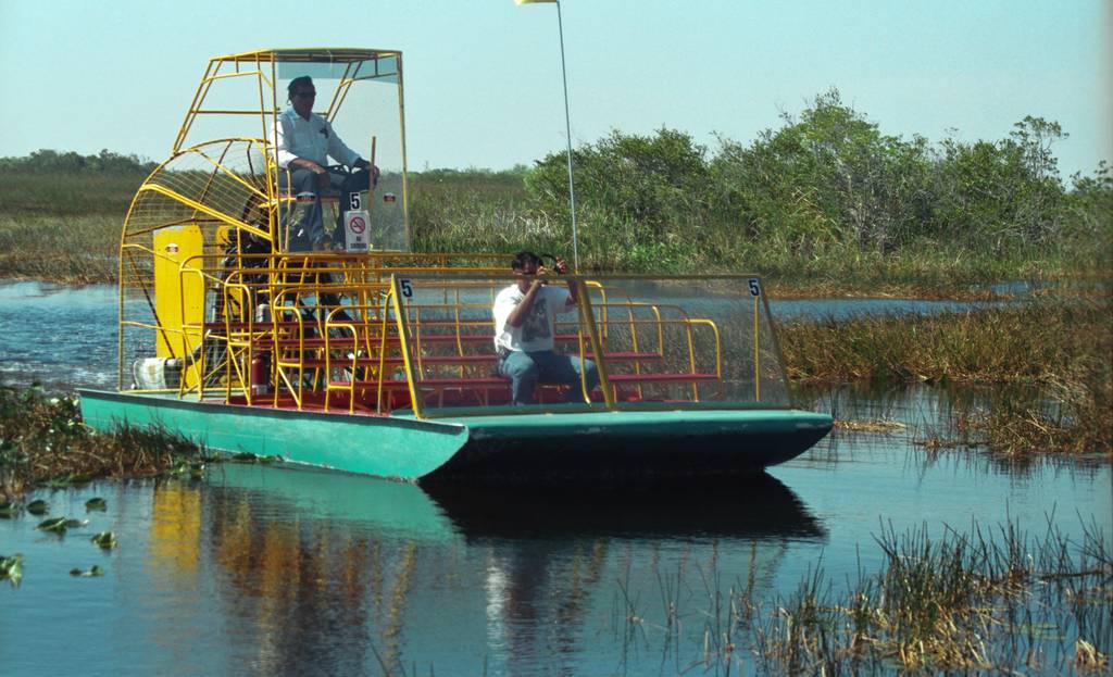 Airboat navigating through sawgrass and shallow Everglades waterways