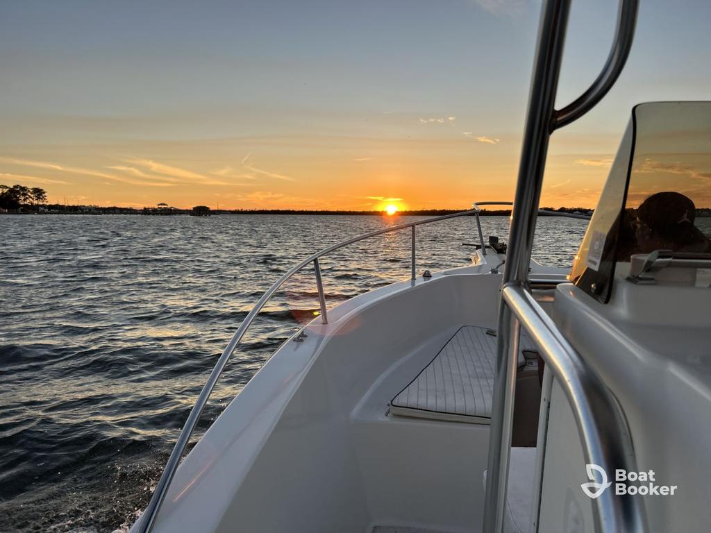You're on a boat at sunset with calm waves and an orange sky. The Boat Booker logo and "Alabama Boating License" appear in the lower right corner.