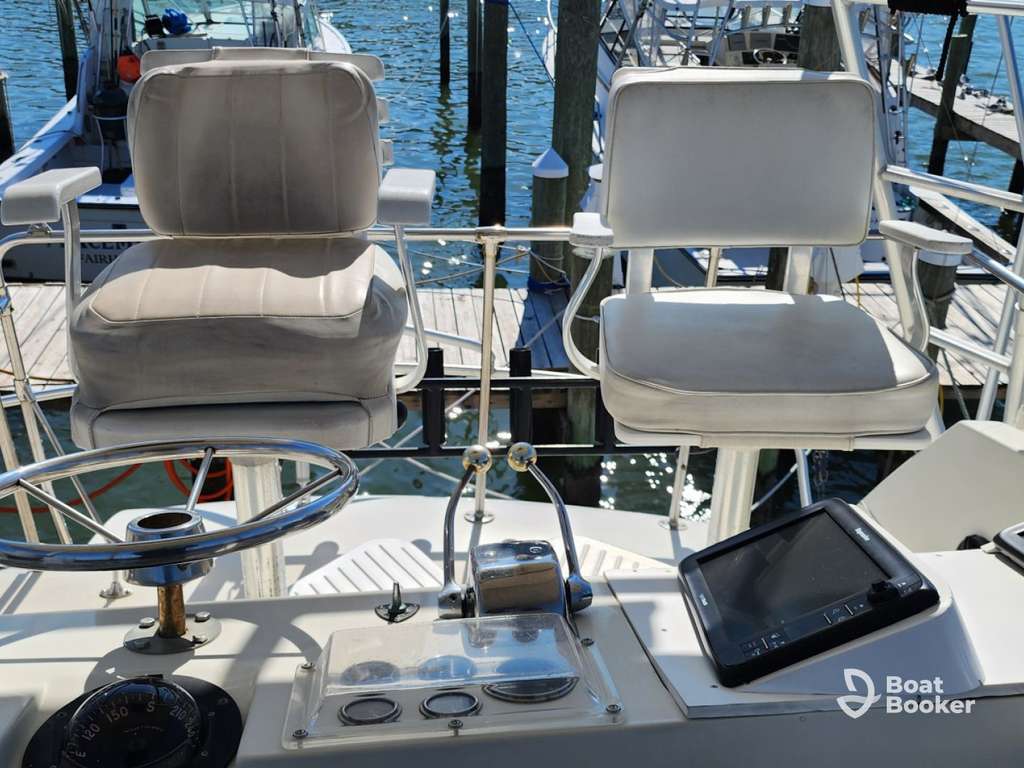 Two white captain’s chairs face forward on a boat’s control deck, so you’re ready to steer with your Alabama boating license and navigate under the bright sunlight.