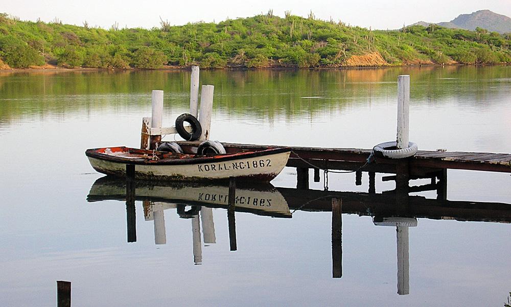 Fishing skiff docked on calm Caribbean water near Curaçao shoreline