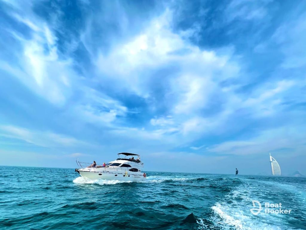 Motor yacht cruising along the Dubai coastline with city skyline
