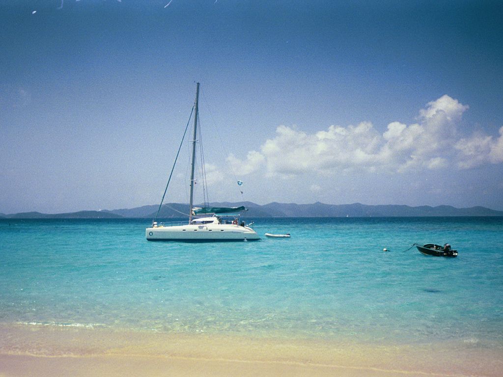 Catamaran sailboat on turquoise BVI waters near White Bay