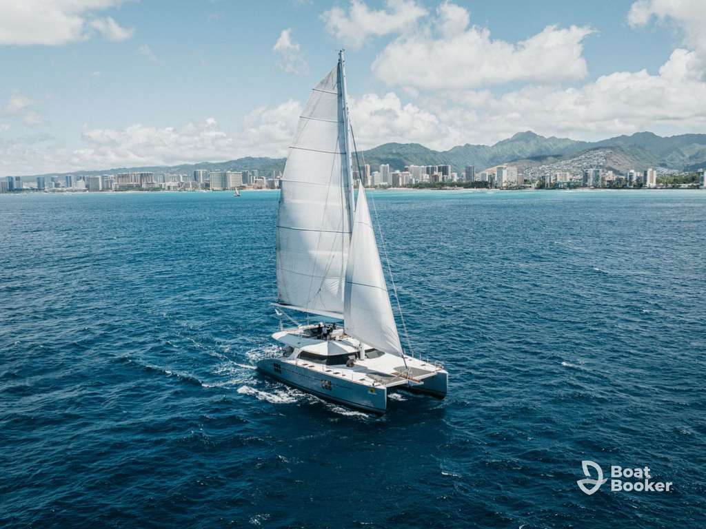 Boat on turquoise Hawaiian waters near a lush green coastline