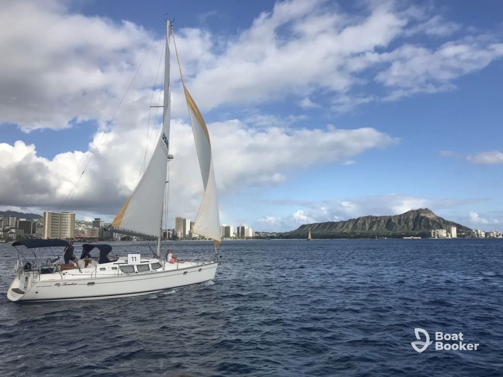 A sailboat’s gliding on the water near a city skyline and volcanic crater—perfect for island hopping in Hawaii beneath a partly cloudy sky.