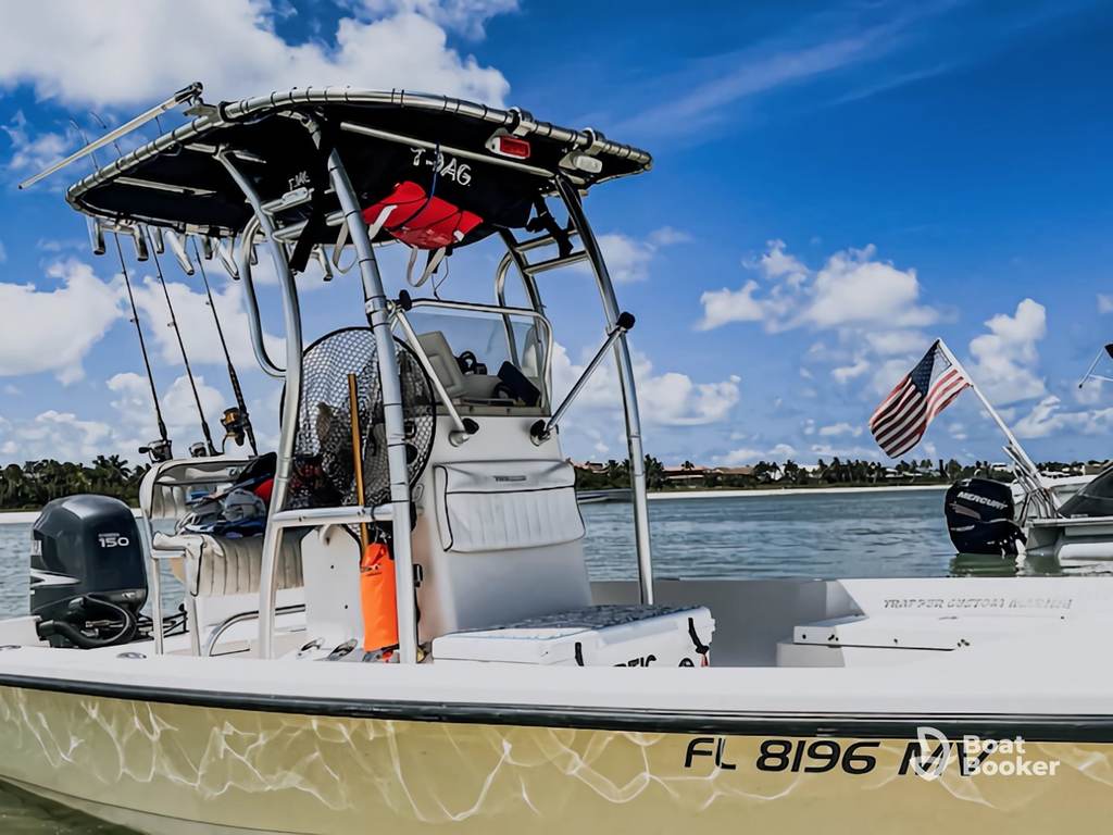 A white center-console fishing boat with a black T-top’s docked in calm water, showing registration number FL 8196 and a U.S. flag at the stern.